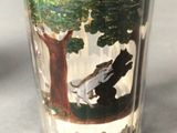 a shot glass with a picture of a horse and a tree on it