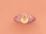 une image représentant une bague ornée d'une pierre jaune entourée de diamants roses et blancs