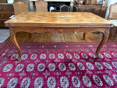 une table avec un plateau en bois posée sur un tapis dans un salon