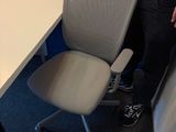a man standing next to a desk with a computer on it