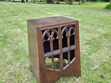 a small wooden cabinet in the middle of a grassy field