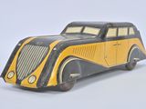 a yellow and black toy car sitting on a white surface