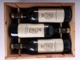 four bottles of wine in a wooden box on a table