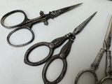 three pairs of scissors sitting on a table next to each other