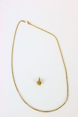 un collier en or orné d'une croix à l'avant et d'une petite croix à l'arrière