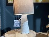 une lampe posée sur une table devant un tableau