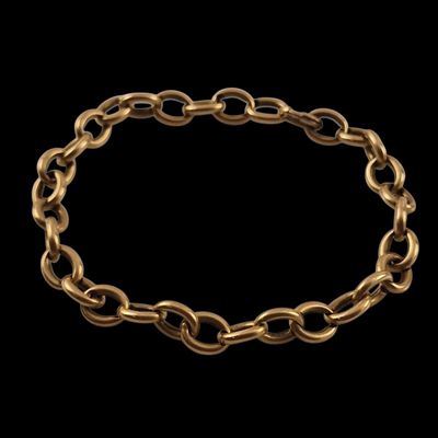 a gold chain bracelet with a clasp on a black background