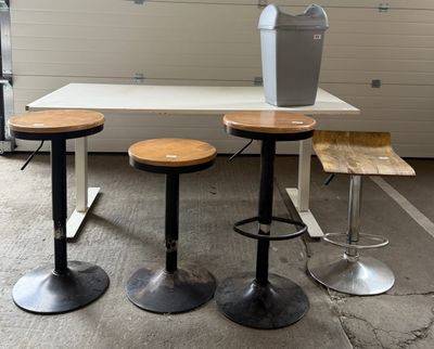 trois tabourets et une table sur laquelle se trouve un vase