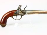 a close up of a gun with a wooden handle on a white surface