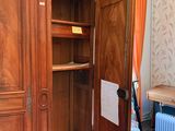 a large wooden cabinet with a door open in a room