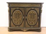 an antique black and gold painted cabinet with two doors