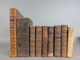 several old books are stacked on top of each other on a table