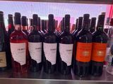 bottles of wine are lined up on a shelf in front of a window