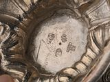 a close up of a silver plate with a flower design on it