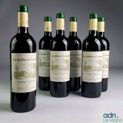 four bottles of red wine are lined up on a table