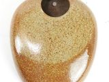 a stone with a hole in it on a white surface