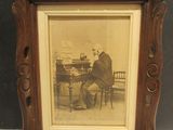 une vieille photo d'un homme jouant du piano, dans un cadre en bois