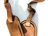étiquettes à bagages en cuir sur fond blanc, avec un cordon marron