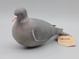un oiseau perché sur une table, avec une étiquette accrochée à lui