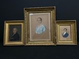 trois portraits encadrés représentant un homme et une femme sur fond noir