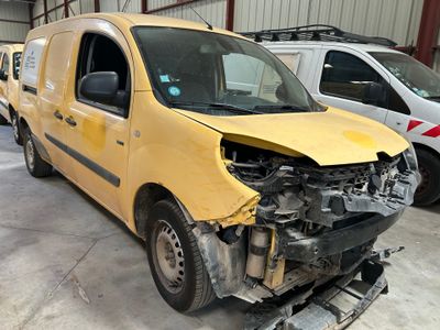 une camionnette jaune qui a été endommagée et qui se trouve dans un garage
