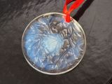 a glass ornament on a table with a red ribbon around it