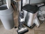 a vacuum that is on the floor next to a trash can