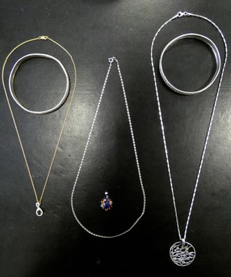 three different types of necklaces and rings on a black surface
