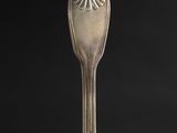 a close up of a silver spoon on a black background