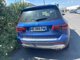 the rear end of a blue mercedes suv parked on the side of the road