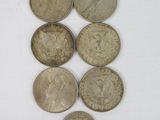 six different coins are arranged in a row on a white surface