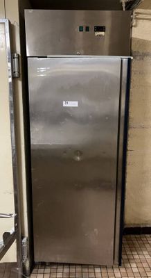 a stainless steel refrigerator in the corner of a room