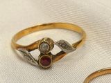 pair of gold rings with garnetts on them on a white cloth