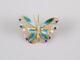 a blue and green butterfly broochle on a white background