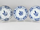 three blue and white plates with floral designs on them