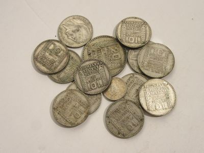 quelques vieilles pièces d'argent posées sur une surface blanche