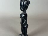 a small statue of a woman with a black head and black hair