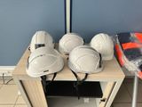 several white hard hats sitting on top of a table next to a blue wall