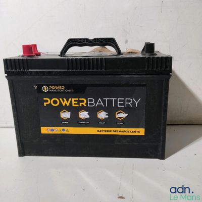 un boîtier de batterie noir et jaune posé sur une table blanche