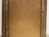 an old picture frame sitting on a tile floor next to a white wall