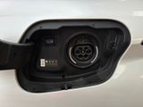 an electric car plugged in to a charging station with a green light