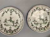 pair of green and white plates with birds and flowers on them