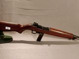 un fusil avec un canon en bois et un support noir sur fond blanc