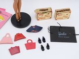 a doll that is standing on a table with other items