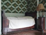 un lit situé dans un coin d'une pièce, avec une lampe