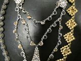 silver and gold necklace with a cross and a cross pendant