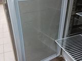 a small refrigerator with a door open on a tiled floor