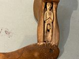 un sabot en bois orné d'une figure sculptée