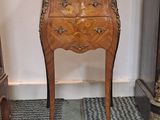 une petite table en bois sur laquelle est posée une horloge