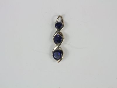 a close up of a blue stone pendant on a white surface